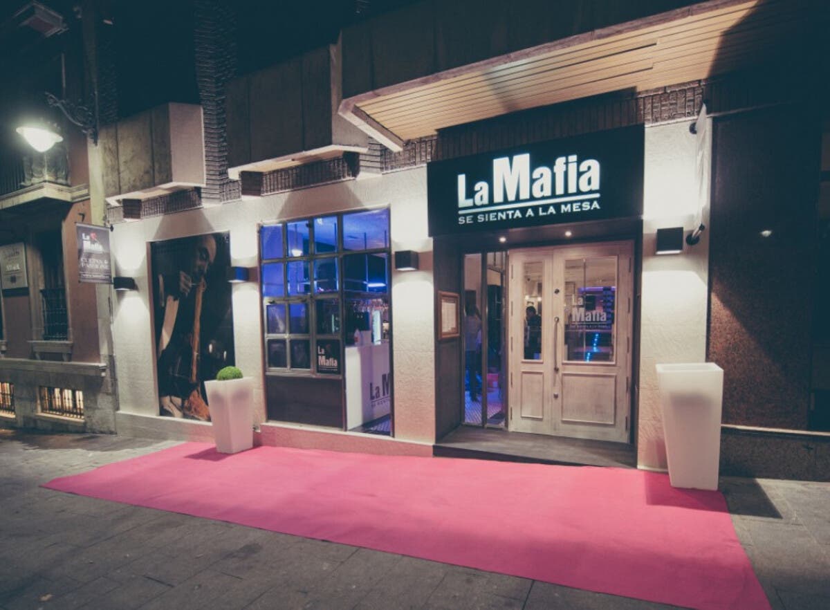 Entrada del restaurante "La Mafia se sienta en la mesa", destacando su emblemático letrero.