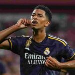 Bellingham: La lesión es más infausta de lo previsto y el Real Madrid teme perderlo dos meses El británico podría perderse el derbi ante el Atlético y los octavos de la Champions League Solo han pasado diez días desde que el madridismo recibió el impacto de la lesión de Jude Bellingham, pero las noticias que llegan desde la enfermería son alarmantes. El centrocampista inglés, que había sido la pieza indispensable tanto para Xabi Alonso como para Álvaro Arbeloa, vio cómo su temporada se truncaba de raíz tras disputar apenas diez minutos contra el Rayo Vallecano. Aunque el diagnóstico oficial del club apuntaba a un problema en el músculo semitendinoso de la pierna izquierda con un mes de baja, nuevas informaciones sugieren que el túnel de recuperación será mucho más largo de lo esperado. Según ha confirmado el comunicador Ramón Álvarez de Mon, la dolencia del británico es más compleja de lo que se estimó inicialmente. La previsión de 30 días de ausencia se ha quedado corta y ya se habla de un periodo de baja de hasta dos meses. Este nuevo escenario es crítico para el Real Madrid, que se adentra en la fase más decisiva del curso con todas las competiciones en juego y sin su principal referente en la creación y llegada al área. Si se confirma este plazo de ocho semanas, el Real Madrid tendrá que sobrevivir a un maratón de partidos sin Bellingham que incluye citas clave en LALIGA ante el Elche, el Mallorca y, especialmente, el derbi frente al Atlético de Madrid. Además, en el plano internacional, el británico se perdería la eliminatoria completa de los octavos de final de la Champions League y llegaría al límite de tiempo, sin ritmo de competición, para una hipotética ida de cuartos de final. Jude Bellingham señalándose el oído durante una celebración, reflejando su importancia goleadora en el Real Madrid.