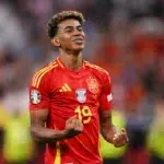 Lamine Yamal, extremo de la Selección Española con la camiseta roja número 19, celebrando con los puños cerrados y gesto de rabia durante un partido oficial.