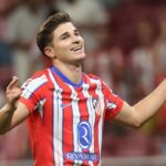 Julián Álvarez celebrando un gol con el Atlético de Madrid, señalando al cielo.