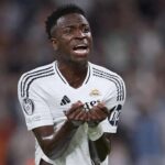 Vinícius Jr. cabizbajo y retirándose las vendas de las manos tras ser sustituido entre pitos en el Bernabéu ante el Betis.