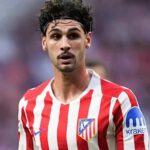 Johnny Cardoso, mediocentro del Atlético de Madrid con cinta en el pelo y camiseta rojiblanca, mirando con atención durante un encuentro de LaLiga.