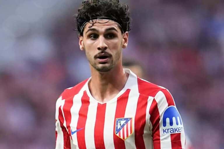 Johnny Cardoso, mediocentro del Atlético de Madrid con cinta en el pelo y camiseta rojiblanca, mirando con atención durante un encuentro de LaLiga.