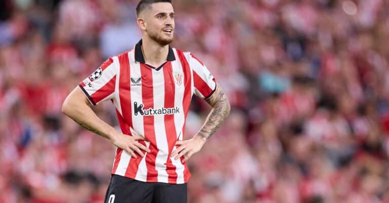 Oihan Sancet, jugador del Athletic Club con la camiseta rojiblanca, con las manos en la cintura y expresión pensativa durante un partido.