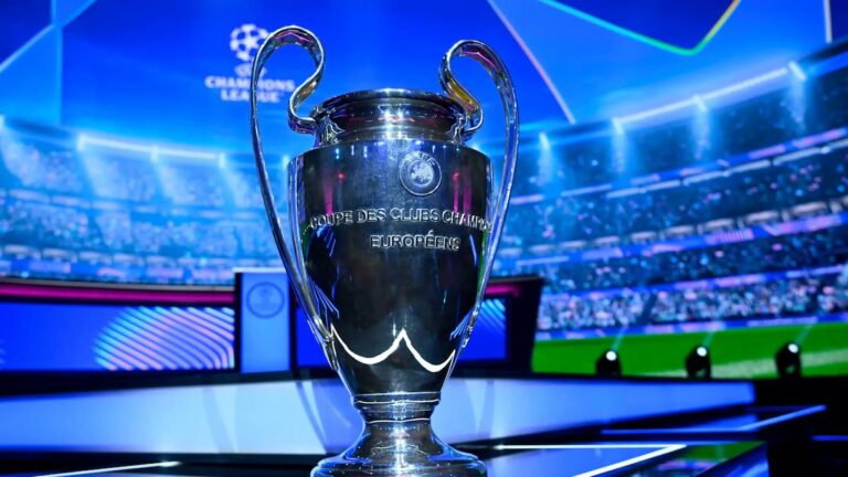 Trofeo de la UEFA Champions League en un estadio iluminado antes de los sorteos de repesca.
