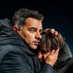 Míchel, entrenador del Girona FC, abrazando y consolando a uno de sus jugadores tras un partido, reflejando su evolución hacia una gestión emocional.