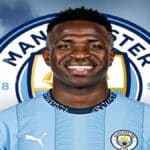 Montaje de Vinícius Jr. con la camiseta del Manchester City y el escudo del club de fondo.