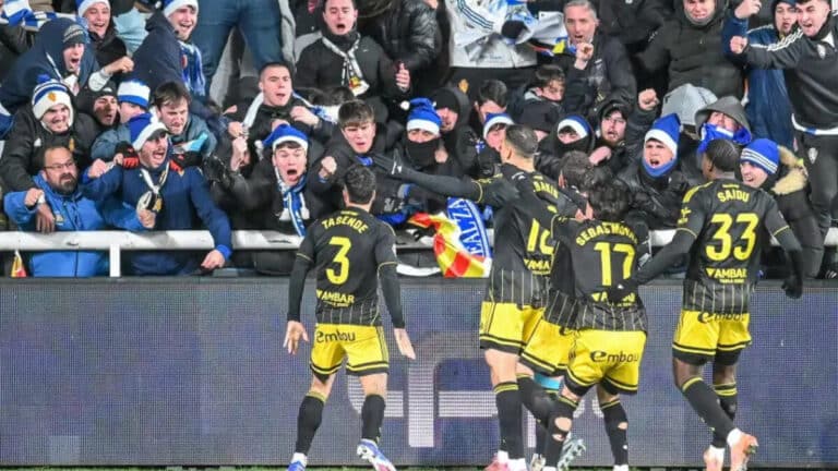 Jugadores del Real Zaragoza celebrando un gol con la grada del Ibercaja Estadio de fondo.