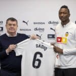 Umar Sadiq posando con la camiseta del Valencia CF junto a Ron Gourlay durante su presentación en Paterna