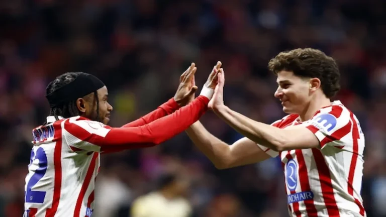 Julián Álvarez y Ademola Lookman chocan las manos celebrando un gol con el Atlético de Madrid frente al Barcelona.