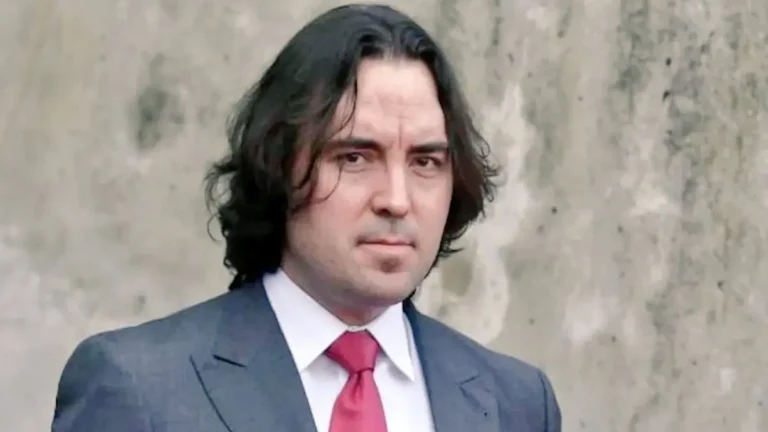 Primer plano de Raúl Martín Presa, presidente del Rayo Vallecano, con traje gris y corbata roja.