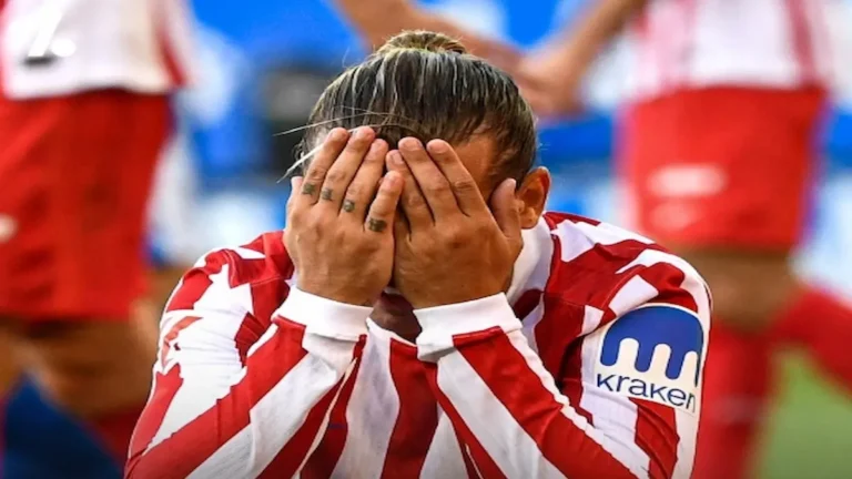 Primer plano de un jugador del Atlético de Madrid con la camiseta rojiblanca tapándose la cara con ambas manos en un gesto de absoluta frustración tras la derrota ante el Rayo Vallecano.