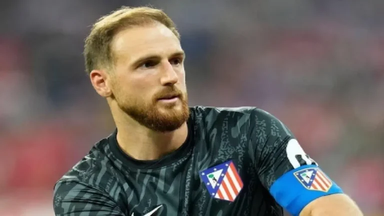 Jan Oblak, portero del Atlético de Madrid con barba y el brazalete de capitán azul, mirando fijamente con gesto serio durante el partido ante el Rayo Vallecano.