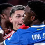 Primer plano de Vinícius Jr. de espaldas y Gianluca Prestianni de frente durante un momento de tensión en el partido entre Benfica y Real Madrid en febrero de 2026.