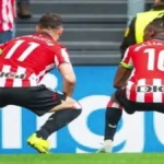 Nico Williams y Gorka Guruzeta celebrando un gol del Athletic Club sentados sobre el césped de San Mamés.