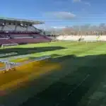 Operarios trabajando en el césped del Estadio de Vallecas con lámparas de calor cedidas por el Valladolid para el Rayo-Atlético.