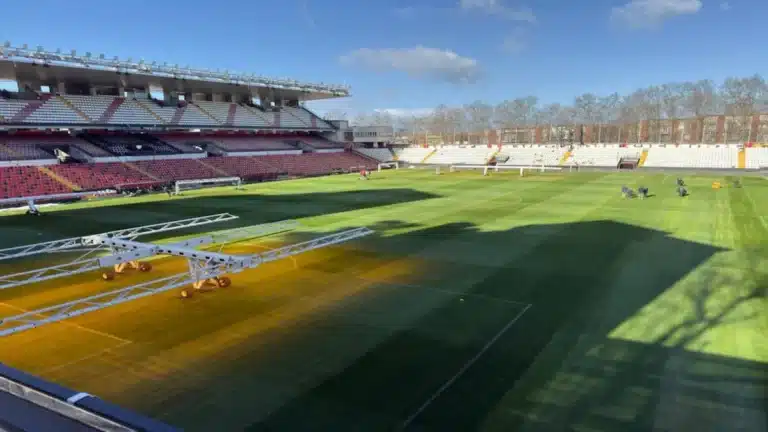 Operarios trabajando en el césped del Estadio de Vallecas con lámparas de calor cedidas por el Valladolid para el Rayo-Atlético.