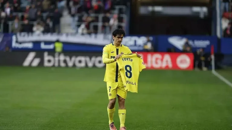 Gerard Moreno, delantero del Villarreal CF, sosteniendo una camiseta con el dorsal 8 de Foyth en un gesto de apoyo durante un partido previo a su lesión