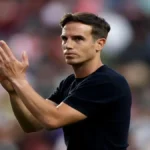 Íñigo Pérez, entrenador del Rayo Vallecano, aplaudiendo con gesto serio durante un partido en 2026.