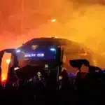 Miles de aficionados del Athletic Club rodeando el autobús del equipo con bengalas rojas y humo en los prolegómenos de un partido en San Mamés.