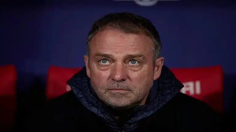 Primer plano del entrenador Hansi Flick con gesto serio y pensativo durante un partido del FC Barcelona.