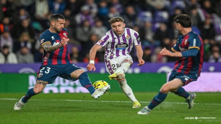 Jugador del Real Valladolid dispara a puerta entre dos defensas del Huesca durante el partido de LaLiga Hypermotion en el José Zorrilla