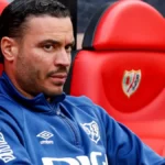 Raúl de Tomás con gesto serio sentado en el banquillo del Rayo Vallecano durante un partido de LaLiga.