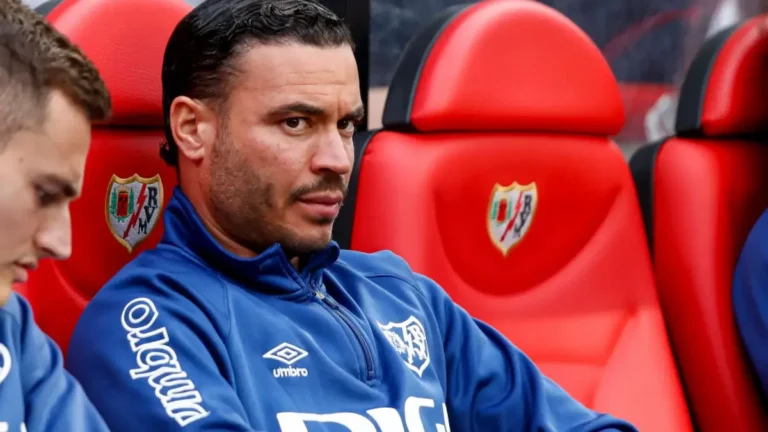 Raúl de Tomás con gesto serio sentado en el banquillo del Rayo Vallecano durante un partido de LaLiga.