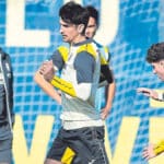 Gerard Moreno realizando ejercicios de estiramiento durante un entrenamiento del Villarreal CF bajo la supervisión médica.