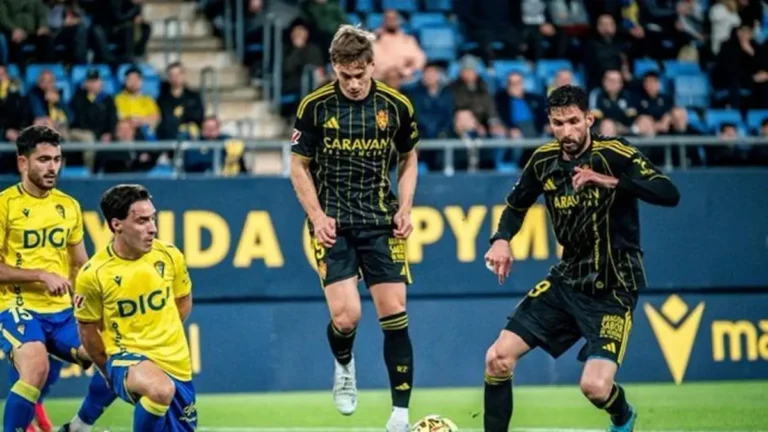 Jugadores del Real Zaragoza celebrando la victoria en Cádiz que recorta a cinco puntos la distancia con la permanencia en la Liga Hypermotion con David Navarro en el banquillo