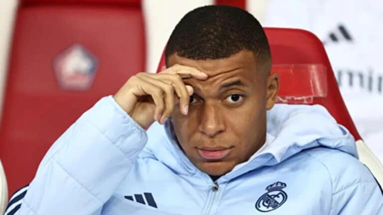 Kylian Mbappé en el banquillo del Real Madrid durante un partido de Champions League, en el contexto de su lesión de rodilla y la crisis con el club