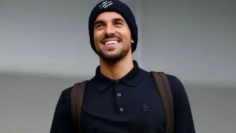 Dani Ceballos sonriente con ropa de calle y mochila, en los aledaños de Valdebebas