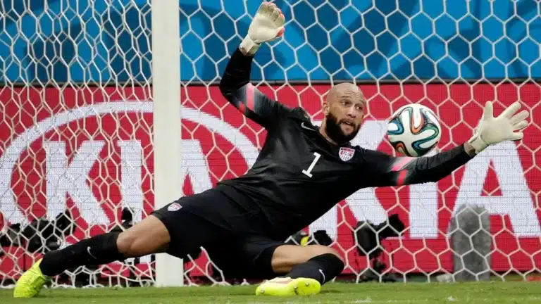 Portero con dorsal 1 de EE.UU. se lanza para desviar el balón con la mano derecha extendida ante una portería llena, recordando el récord que Eloy Room rozó ante Ecuador en el Mundial 2026