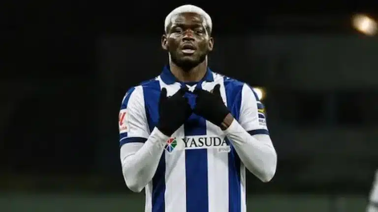 Marius Mouandilmadji con la camiseta azul y blanca del Samsunspor celebrando con gesto de oración mirando al cielo durante un partido nocturno