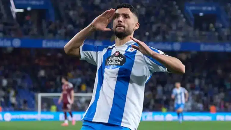 Jugador del Deportivo celebra un gol con las manos junto a la cara y la grada al fondo