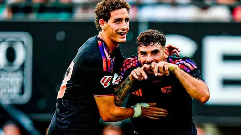 Dos futbolistas del Sevilla FC celebran abrazados un gol vestidos con la tercera equipación negra