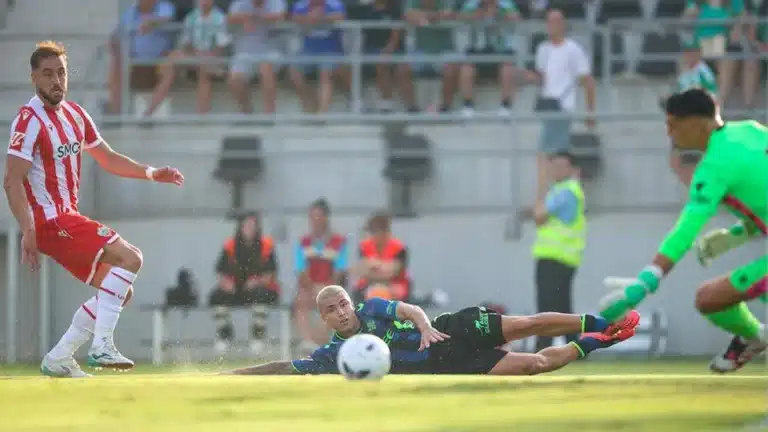Un jugador del Betis remata tumbado en el césped ante la estirada del portero del Almería