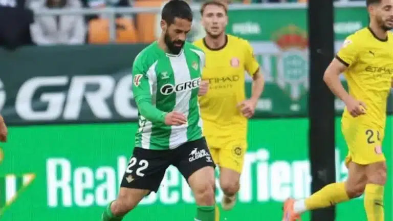 Isco conduce el balón con la camiseta del Real Betis ante un rival de amarillo