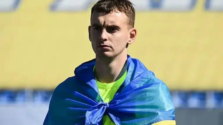 Oleksandr Saputin envuelto en la bandera de Ucrania tras un partido con la selección