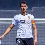 Rubén Iranzo camina sobre el césped con la camiseta blanca del Valencia y el dorsal 15