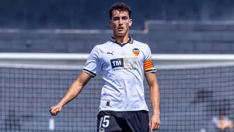 Rubén Iranzo camina sobre el césped con la camiseta blanca del Valencia y el dorsal 15