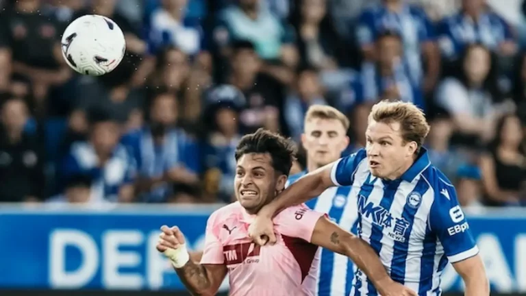 Jugador del Valencia con la camiseta rosa disputa un balón aéreo con un defensor del Alavés