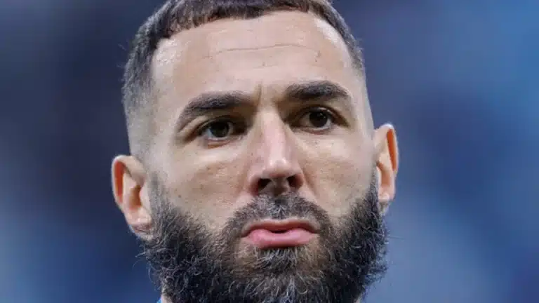 Primer plano de Karim Benzema con chándal azul y barba, mirando al frente antes de un partido
