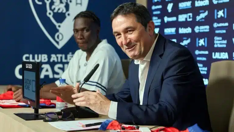 Braulio Vázquez sonríe y aplaude en la sala de prensa de Osasuna junto a un jugador del primer equipo