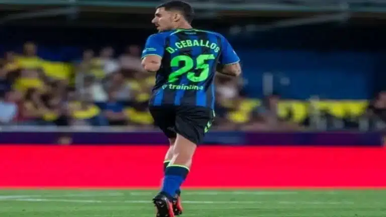 Dani Ceballos, de espaldas con el dorsal 25 de la tercera equipación azul y negra del Betis, sobre el césped de La Cerámica
