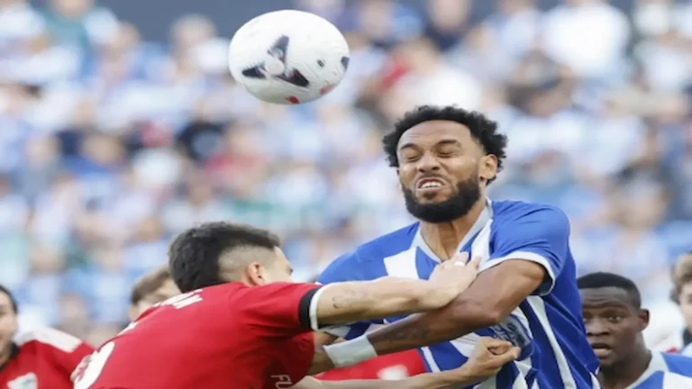 Un jugador del Deportivo remata de cabeza presionado por un rival del Sevilla en un duelo aéreo en Riazor