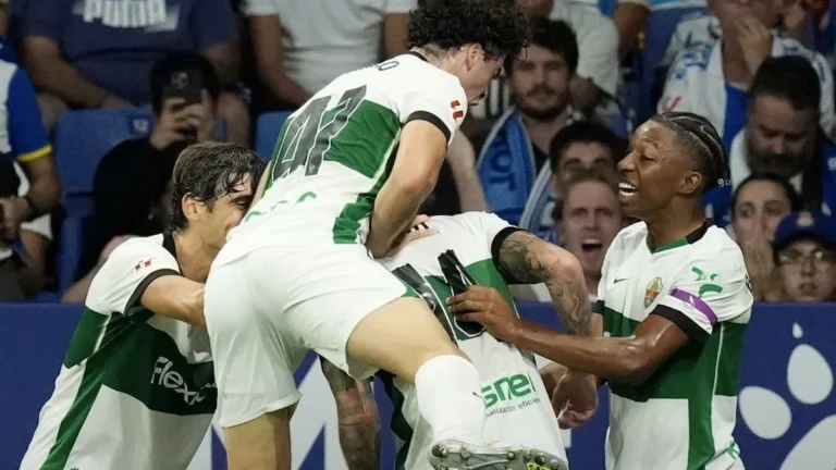 Jugadores del Elche celebran un gol saltando sobre un compañero en el campo