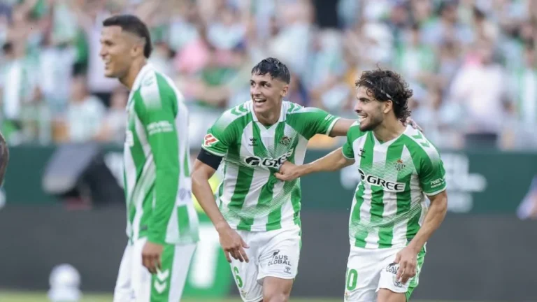 Ez Abde, con el dorsal 10 del Betis, celebra sonriente junto a Facundo Bernal y otro compañero ante la grada
