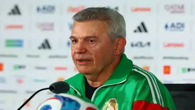 Javier Aguirre habla en rueda de prensa con el chándal verde de la selección de México ante un panel de patrocinadores