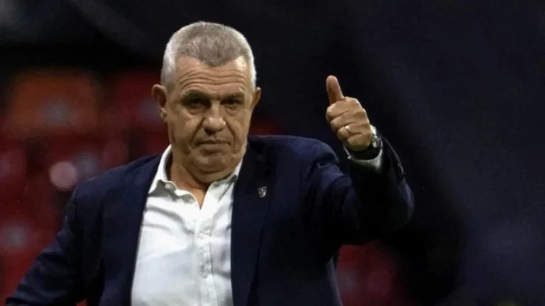 Javier Aguirre, con gesto serio, levanta el pulgar en el banquillo durante un partido